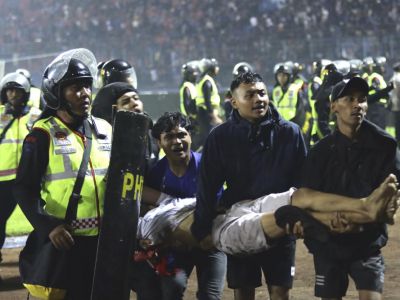 Футбольные болельщики несут раненого после столкновений на стадионе Канджурухан в Маланге. Фото: Yudha Prabowo / AP